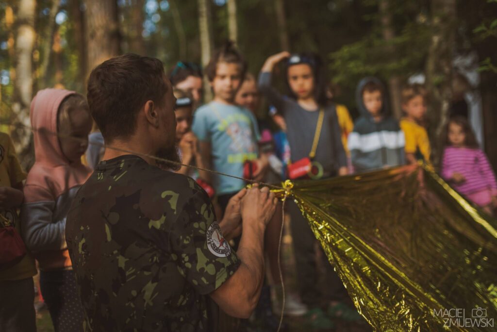 Dzieci bawiące się na świeżym powietrzu podczas terenowych urodzin survivalowych.